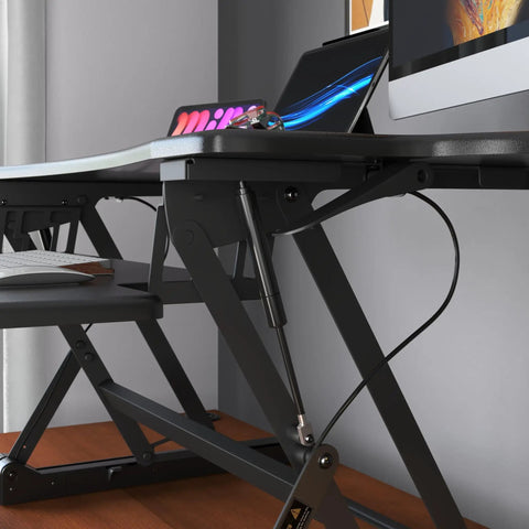 Side view of Standing Desk Converter 48 Inch Wide Sit Stand Desk Riser with dual monitors, keyboard tray, black finish.