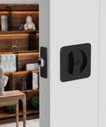 Installed black pocket door lock for sliding doors with privacy latch and rounded corner square hardware.