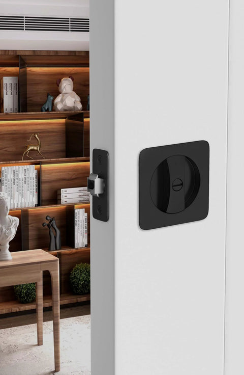 Installed black pocket door lock for sliding doors with privacy latch and rounded corner square hardware.
