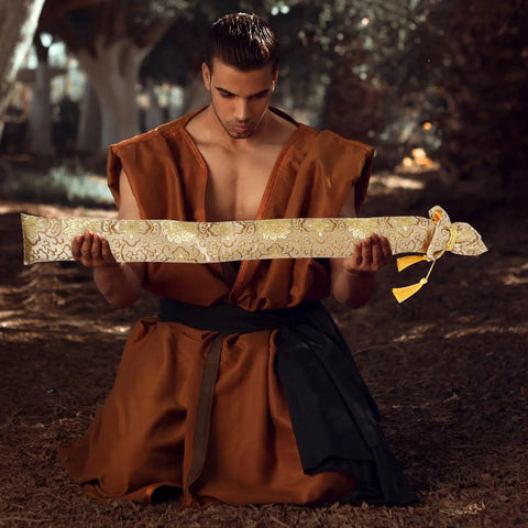 Man holding Silk Brocade Carrying Bag With Tassel 53 Inch Sword Case For Katanas Tai Chi Broadswords Wakizashi And Cosplay Gear In Floral Gold Dust