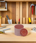 150 Piece Inch 8-Hole Hook And Loop Sanding Discs Assorted Grit Set for power tool grinders on a workbench.