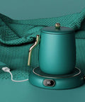 Keep Your Morning Brew Nice And Toasty With This USB Coffee Mug Warmer Featuring Three Adjustable Heat Levels Dial Knob Control Splash Resistant Build Eight Hour Safety Timer And Sleek Green Finish For Real Deal Comfort, showcasing a sleek teal mug warmer.