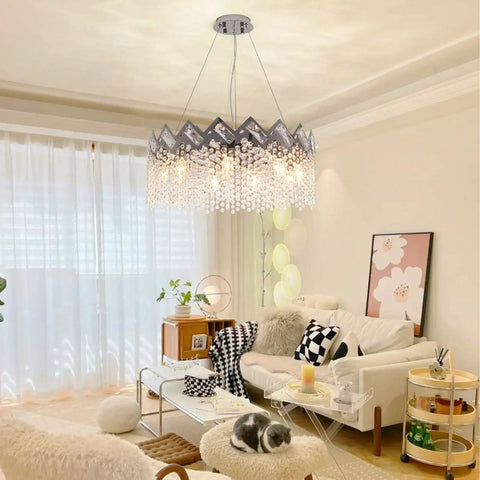 Dope Modern K9 Crystal Chandelier With Nine Lights Raindrop Pendant Ceiling Light Chrome Finish illuminating a cozy living room.