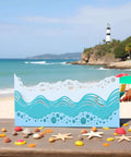 Beach Wave Metal Cutting Dies Set For Scrapbooking And Card Making on a beach background with sea shells and lighthouse.