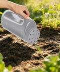 Adjustable Handheld Seed Shaker And Spreader For Fertilizer Grass Seed Ice Melt And Lawn Care Premium Durable Portable All Season Spreader In Gray For Easy Grab And Go Lawn Maintenance in hand over garden soil