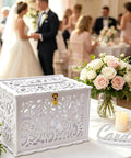 Slick White Silhouette Wedding Card Box With Lock And Slot, Dope Floral Hollow Envelope Holder displayed at wedding reception.