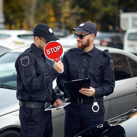 Two Sided Stop And Go Handheld Sign Kit With Handle Waterproof Plastic Traffic Sign held by uniformed personnel.