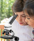 Two children using Powerful Biological Microscope For Adults And Kids 100X-2000X With Phone Adapter And Slides Set outdoors
