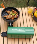 Portable Butane Gas Camping Stove With 7500 BTU Output Ultra Compact Folding Design on wooden table with cooking pan