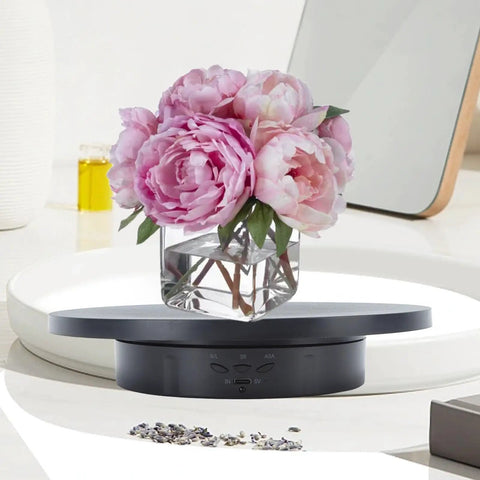 Stylish Electric Rotating Jewelry Display Turntable With Adjustable Direction And 360 View For Home Studio Showcase with flowers.
