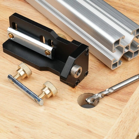 Slick Aluminum Drilling Jig For 20 30 And 40 Series Profile Rails With Integrated Threading Tool on wood surface.