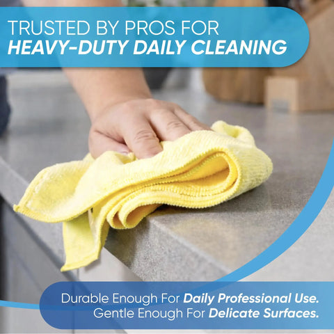 Person using 50 Pack 16x16 Microfiber Cleaning Cloths All Purpose Shop Rags For Janitorial Auto Detailing Restaurants And Home Use Reusable Machine Washable Yellow on countertop.