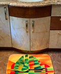 Colorful geometric design bathroom rug mat in front of a bathroom sink.