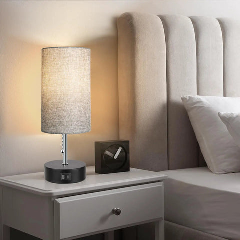 Three Color Temperature Bedside Lamp With USB A Port And USB C Port, placed on nightstand, gray finish, lit by 9W LED bulb.