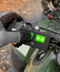 Gloved hand holding AXR1 Water-Resistant 3-Button Remote For Automatic Gate Openers on an ATV dashboard