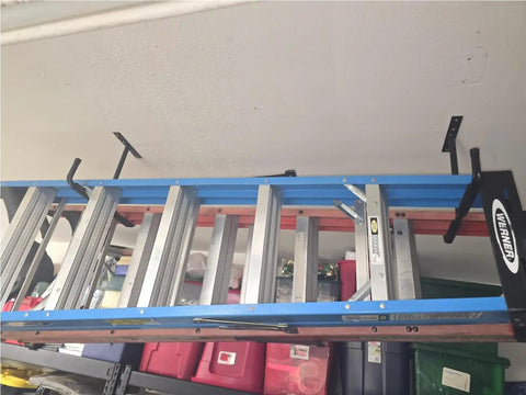 Heavy Duty Ceiling Storage Hooks For Garage Set Must Have, Overhead Rack To Hang Lumber, Ladders, Pipes, Fishing Rods, Bikes And Gear, Space Saving J Hooks, 2 Pack, Sturdy Ceiling Mounted Organizer holding a ladder