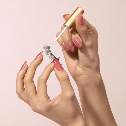 Person applying Clear Lash Adhesive For Strip Lashes And Lash Clusters, Waterproof All Day Hold, Latex Free With Aloe, using brush applicator