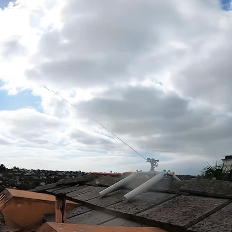 Heavy Duty Rooftop Sprinkler System For Wildfire Defense Featuring A Built Damn Tough Black Frame And Premium Brass Nozzles spraying water on a roof.
