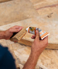 Person applying Max Strength Construction Adhesive Crystal Clear Two And A Half Ounce Squeeze Tube Waterproof Gap Filling