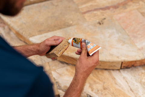 Person applying Max Strength Construction Adhesive Crystal Clear Two And A Half Ounce Squeeze Tube Waterproof Gap Filling