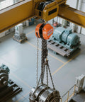 Orange hand chain hoist, 3-ton capacity, installed on yellow overhead beam with steel chain