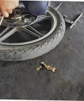 Mechanic adjusting wheel with Off Road Ball Joint Kit For ATVs And Go Karts, Adjustable Suspension Parts nearby on ground.