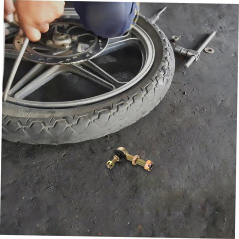 Mechanic adjusting wheel with Off Road Ball Joint Kit For ATVs And Go Karts, Adjustable Suspension Parts nearby on ground.