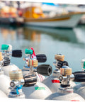 Close-up of diving tank valve replacement part for scuba tanks easy install accessory with durable build near docked boats.