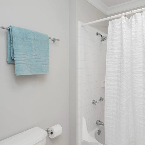 White Plastic Bath Tub Splash Guard 9 Inch By 10.75 Inch Curved Water Redirector For Shower Enclosures visible in bathroom corner