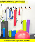 Gym wall with equipment stored on Two Pack Heavy Duty Garage Hooks For Wall Mount Storage, Ultra Sturdy Steel U Hooks.