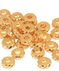 Gold Plated 5.8mm Textured Spacer Beads, Laser Cut Round Metal Rings For Bracelets And Jewelry Making, 1.8mm Hole, Sparkling Reflective Finish, Available In 10, 30, Or 50 Piece Sets. gold spacer beads stacked on white background