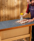 Man using a router on a Heavy Duty Rubber Workbench Mat 2x5 Feet for Woodworking, Garage, and Tool Benches, built tough and grippy.