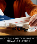 Person adjusting elevons on Iconic Concorde Model Aircraft Building Kit for Adults with realistic details and functional pieces.