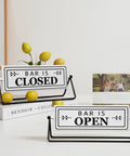 Smooth Flipping Open Closed Sign, Handmade Metal Counter Decor For Your Cozy Home Bar Or Office Coffee Spot With Black Stand And Embossed Lettering. Bar is Open and Bar is Closed signs displayed.