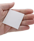 Hand holding Shine Rite 2-Inch Polishing Pads For Jewelry, Pre-Treated Foam Squares With Micro Abrasives, Pack Of 50.