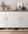Front view of white cabinet with matte black aluminum alloy handles, showcasing a stylish decor with flower vase and art print
