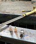 Beefed Up Medium Duty Hand Torch For Industrial Cutting And Welding With Interchangeable Tips on metal surface in workshop