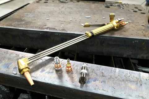 Beefed Up Medium Duty Hand Torch For Industrial Cutting And Welding With Interchangeable Tips on metal surface in workshop