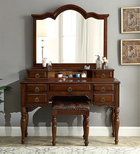 Antique vanity dresser with mirror featuring brass cabinet pulls and leather stool, classic wooden design with vintage accents.