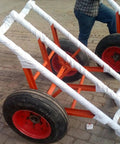 Beefed Up Heavy Duty Double Utility Pole Dolly With Two Wheel Concrete Pole Transport Cart For Electrical Crews Built Tough With Solid Steel Frame Easy Maneuver On Rough Job Sites And Heavy Poles, orange steel frame with two wheels
