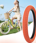 Orange 20x2.35 Bike Tire Set For BMX MTB next to a girl on a bicycle in a sunny field