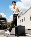 Man walking outside pulling Compact 16 Inch Carry On Luggage With Front Laptop Pocket And TSA Lock With Wheels Airline Approved Hard Shell Suitcase For Travel Front Access Compartment Fits A 15.6 Inch Laptop Lightweight Durable Black Lekebobor.