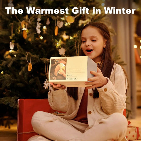 Girl holding Cozy Heated Mouse Pad Hand Warmer gift box by Christmas tree, showcasing product packaging.