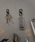 S Biner MicroLock Stainless Steel Key Holder Carabiner Clip Set Of 5 With Locking Gates holding keys and multitool on workbench