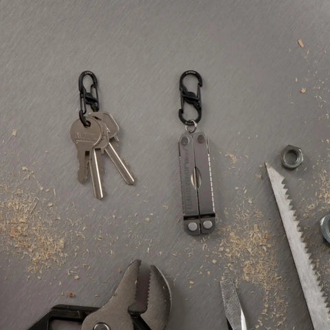 S Biner MicroLock Stainless Steel Key Holder Carabiner Clip Set Of 5 With Locking Gates holding keys and multitool on workbench