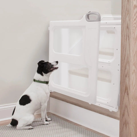 Adjustable White Baby Safety Gate With Dual Mount Capability, Pressure Mount Or Hardware Mount, shown on stairs with dog