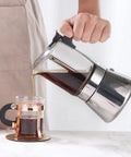 Pouring coffee from Induction Friendly Moka Pot With Crystal Glass Top And Stainless Steel Stovetop Espresso Maker Pro Level Brew Classic Italian Coffee Brewer 160ml Transparent Glass Body For Easy Brew Control Durable And Easy To Clean into cup