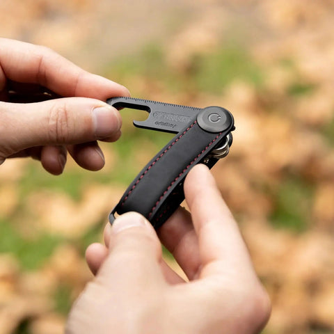 Person using Ultra Slim Stainless Steel Multi Tool V2 With Titanium Coating Pocket EDC Gear for quick bottle opening.
