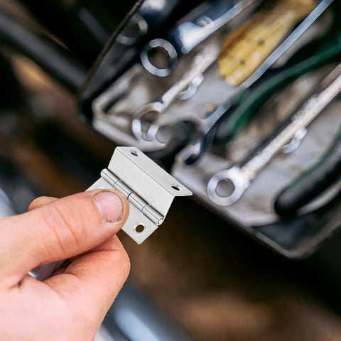 Close-up of hand holding 10 Pack Iron Folding Cabinet Hinges With Right Angle Mount, demonstrating smooth quiet operation.