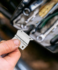 Close-up of hand holding 10 Pack Right Angle Cabinet Door Hinges 180 Degree Full Overlay Flat Iron Hinges with tools visible in background